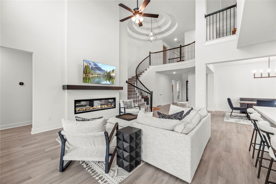 This family room delivers the kind of wow-factor that makes every gathering unforgettable. With beautiful wood-look tile flooring, neutral paint, and a sleek electric fireplace, its clean lines and dramatic details create a space that’s as stylish as it is inviting.