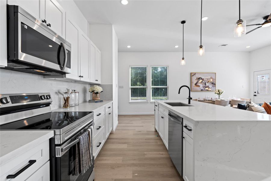 Quartz counters and a tiled backsplash that make cleanup simple and everyday cooking feel elevated. Quartz counters and a tiled backsplash that make cleanup simple and everyday cooking feel elevated.
