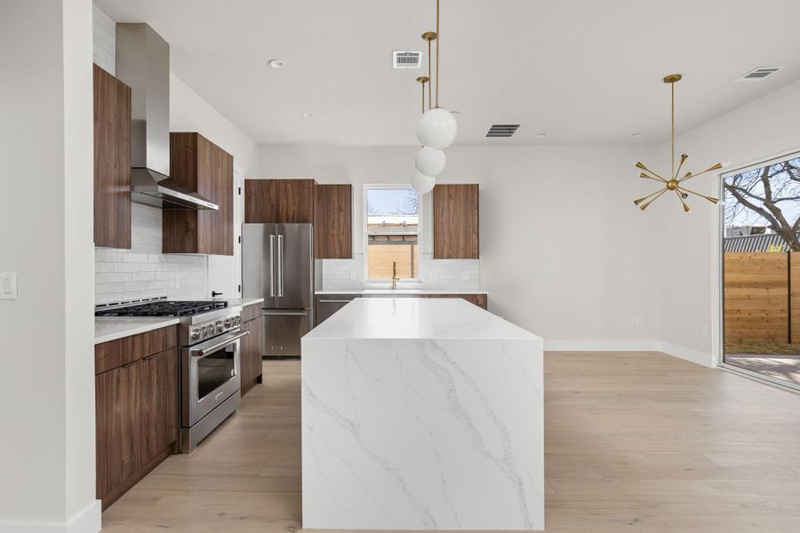 Kitchen with a sink, high quality appliances, visible vents, and modern cabinets