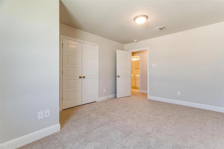 Unfurnished bedroom featuring light carpet and a closet