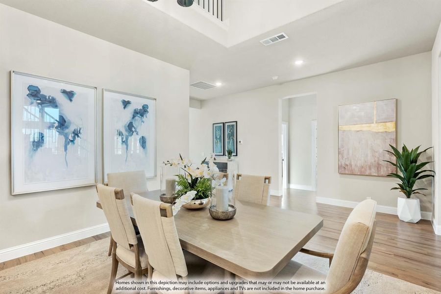 Dining room with wood table, upholstered chairs, high tray ceiling, and hardwood floors Dining room with wood table, upholstered chairs, high tray ceiling, and hardwood floors