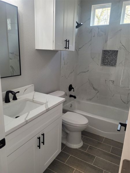 Bathroom with shower / washtub combination, vanity, and wood finish floors
