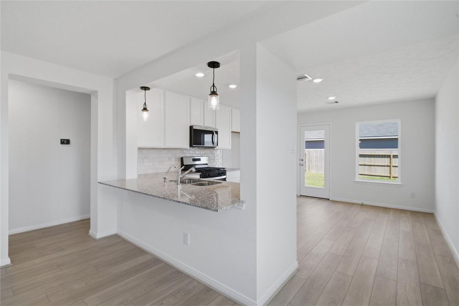 The ultimate hub for daily life—the expansive breakfast bar which offers plenty of room for holiday food prep, casual dining, and hanging out while the chef cooks. Featuring gorgeous pendant lights!