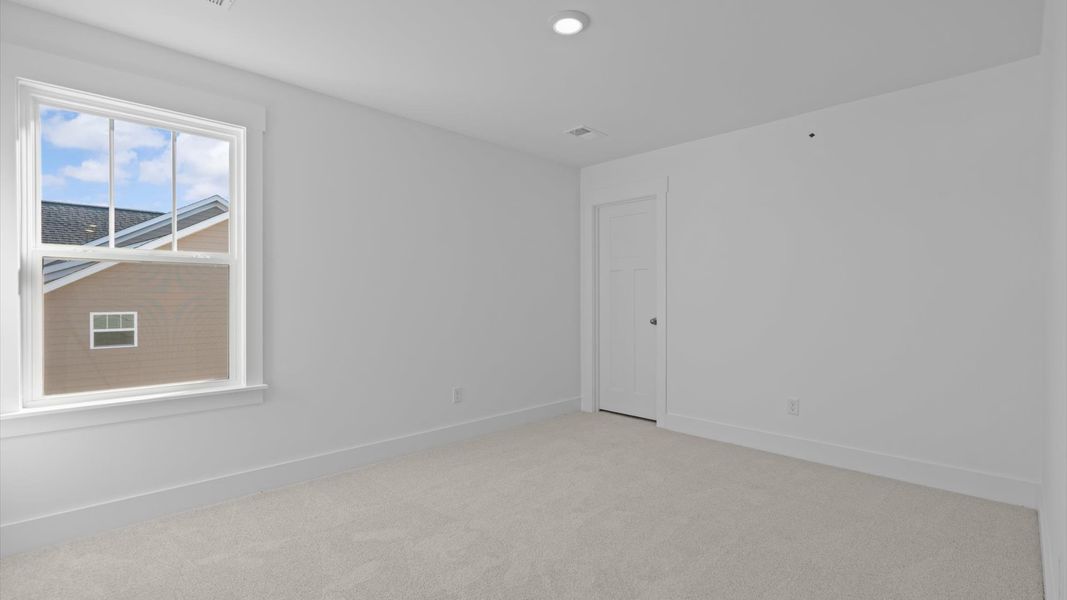 Inviting bedroom with tasteful finishes and large windows that create a fresh, open ambiance