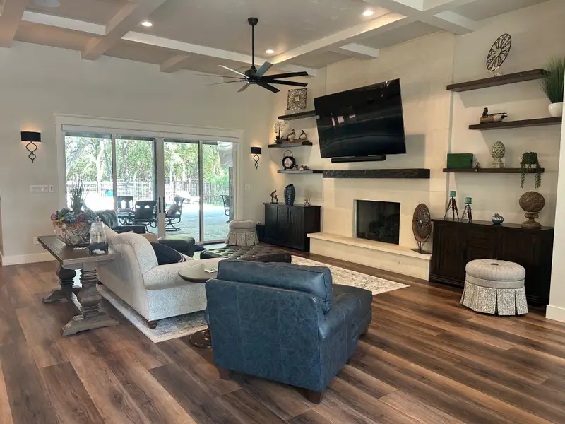 Living area featuring a fireplace, beamed ceiling, recessed lighting, a ceiling fan, and luxury vinyl flooring Living area featuring a fireplace, beamed ceiling, recessed lighting, a ceiling fan, and luxury vinyl flooring
