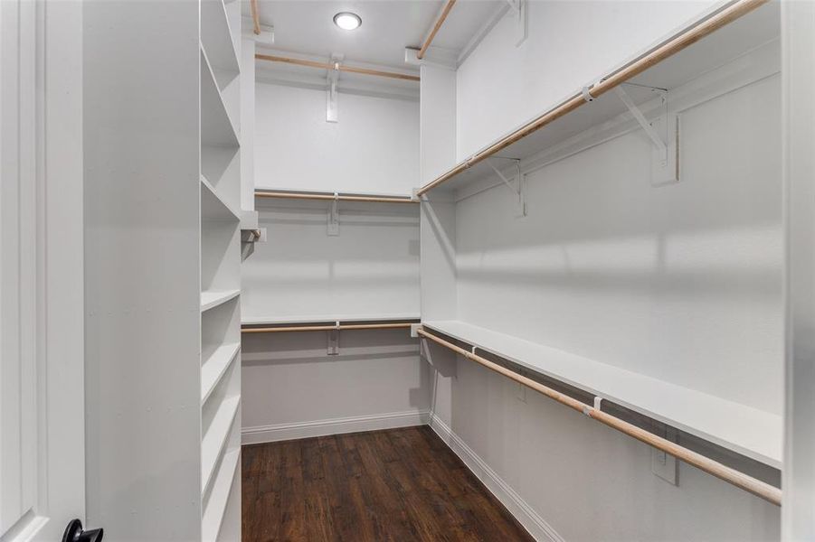 Spacious closet featuring dark wood-type flooring Spacious closet featuring dark wood-type flooring