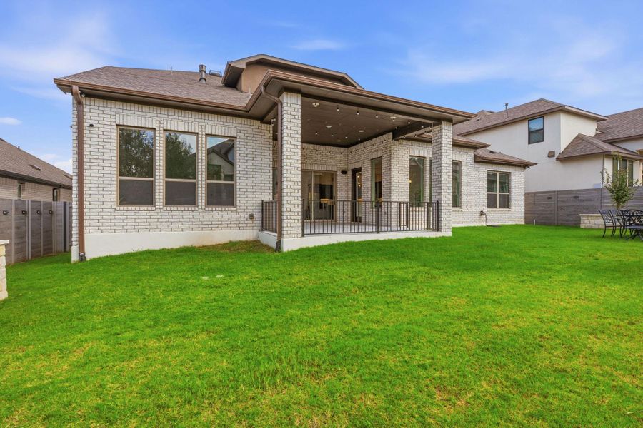 A pristine backyard with a generous lawn and covered patio offers ample space for outdoor enjoyment. A pristine backyard with a generous lawn and covered patio offers ample space for outdoor enjoyment.