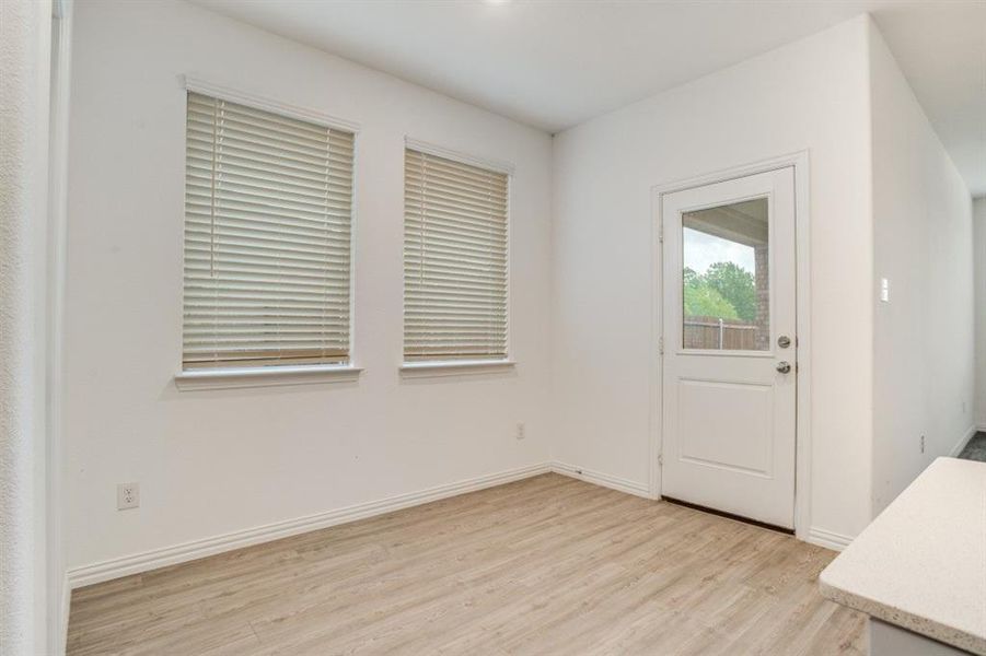 Doorway with wood finished floors and baseboards