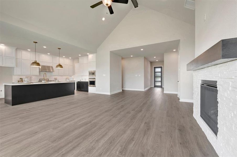 Vaulted ceilings enhance this open concept interior featuring wood-finish flooring