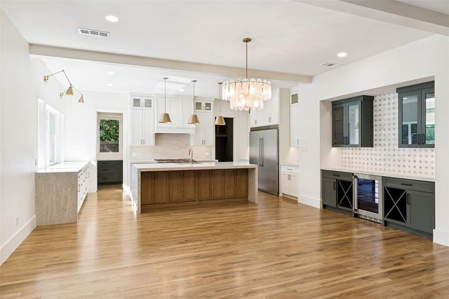 Expansive kitchen and dining area featuring light wood-finish flooring Expansive kitchen and dining area featuring light wood-finish flooring