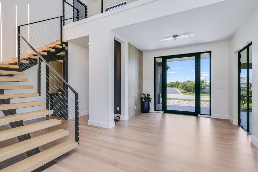 Entrance foyer featuring wood finished floors and modern floating stairs Entrance foyer featuring wood finished floors and modern floating stairs
