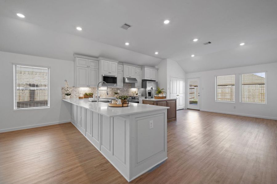 Tons of counter space and smart storage make the kitchen as functional as it is beautiful. The long stretch of windows brings in steady natural light and keeps the whole space feeling fresh and connected to the rest of the home.