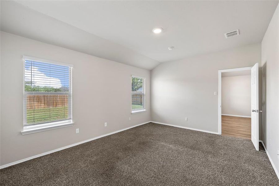 Spare room with dark carpet and vaulted ceiling Spare room with dark carpet and vaulted ceiling