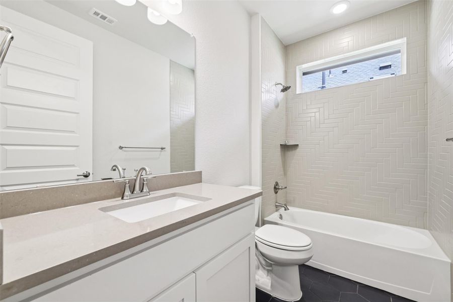 Bathroom with vanity, tile patterned floors, and tub / shower combination