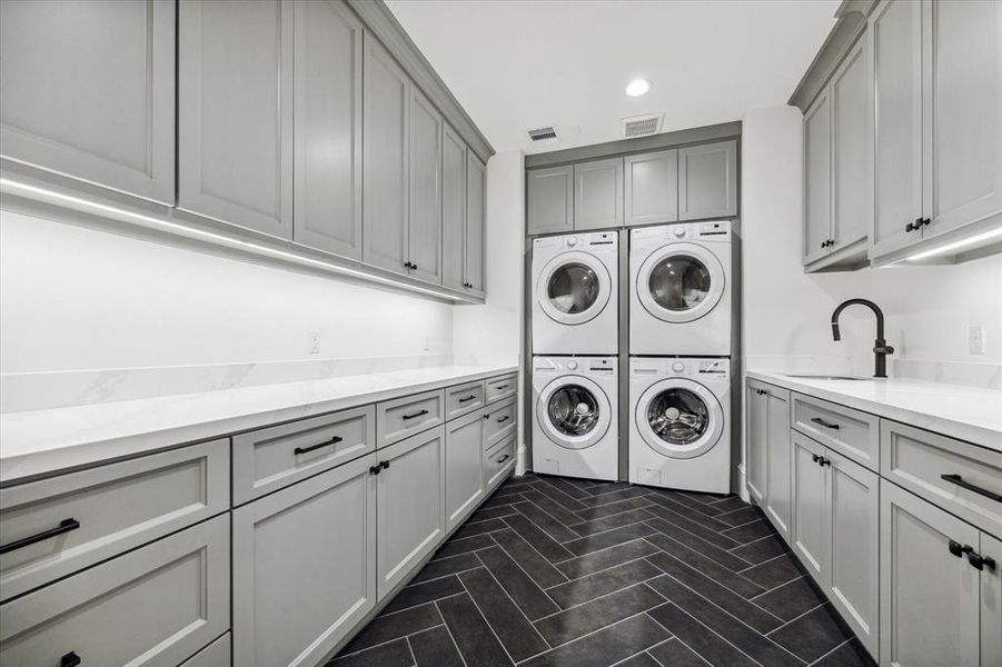 Second-floor utility room, featuring quartz countertops, ample storage, and DOUBLE washers and dryers! Say goodbye to laundry hassles and hello to ultimate efficiency!