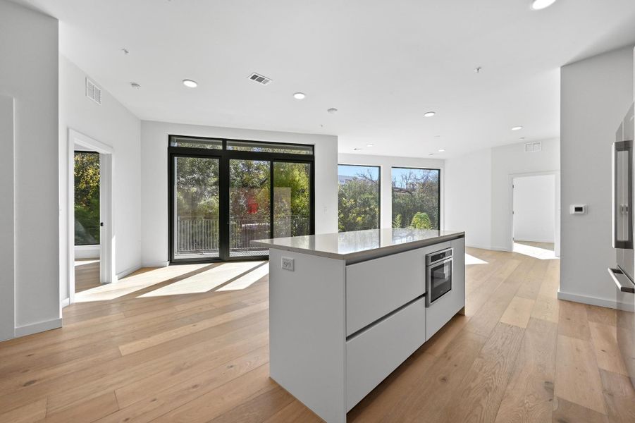 Kitchen featuring modern cabinets, white cabinets, light wood-style flooring, a center island, and recessed lighting Kitchen featuring modern cabinets, white cabinets, light wood-style flooring, a center island, and recessed lighting