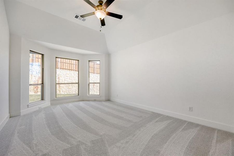 Spare room with light carpet, a ceiling fan, and lofted ceiling