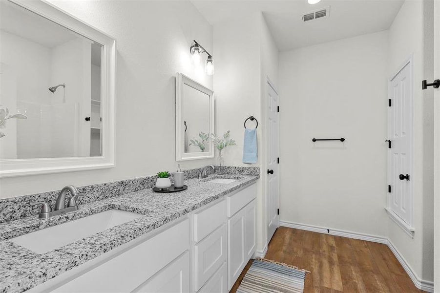 Bathroom featuring dual bowl vanity and hardwood / wood-style flooring