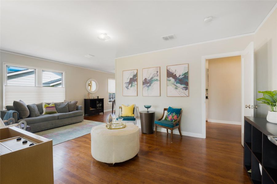 Rich hardwood floors flow through this inviting living area, bathed in natural light from generous windows. Rich hardwood floors flow through this inviting living area, bathed in natural light from generous windows.