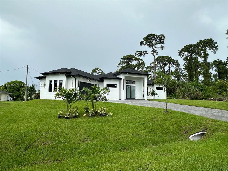 Front exterior of a new home in , Lehigh Acres, FL, highlighting curb appeal (Image 20).