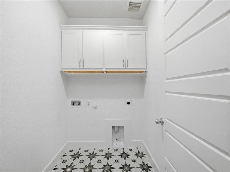 Laundry room with hookup for a gas dryer, cabinet space, tile patterned floors, electric dryer hookup, and hookup for a washing machine