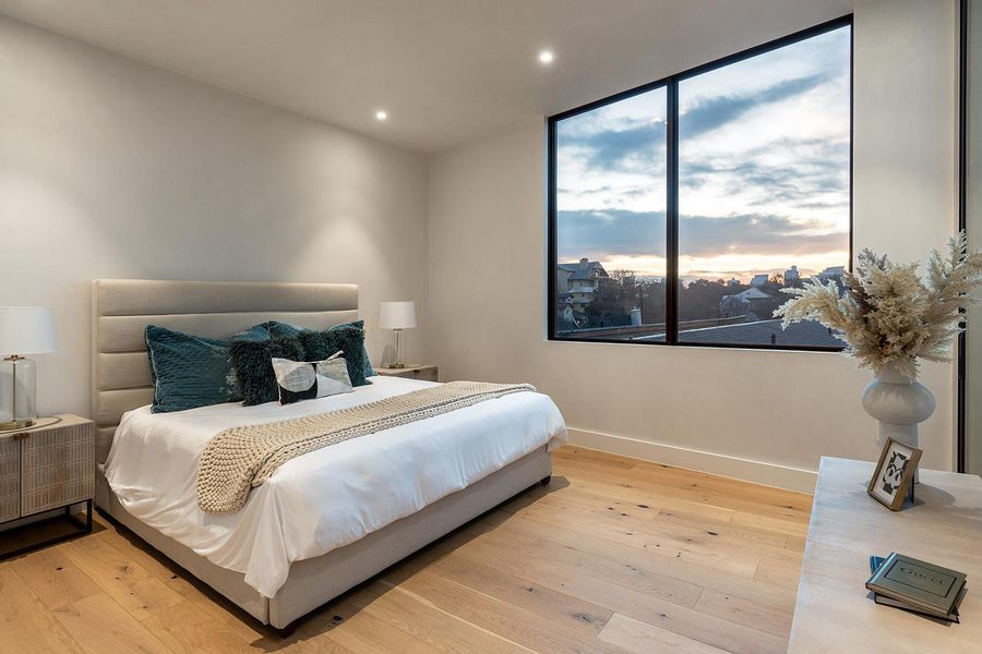 Floor-to-ceiling windows offer captivating city views in this well-lit primary bedroom. Floor-to-ceiling windows offer captivating city views in this well-lit primary bedroom.