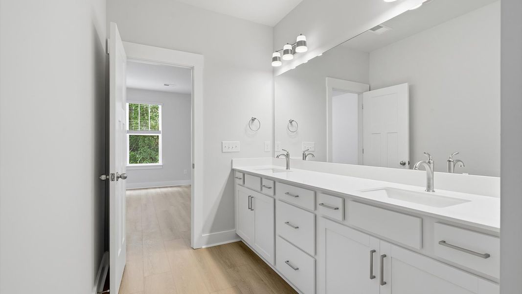 Memorable mornings begin in this elegant primary bathroom with walk-in shower and double vanity
