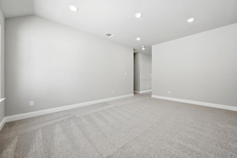 Empty room with light carpet and recessed lighting