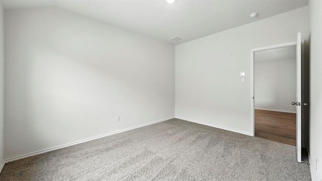 Spacious interior room with light gray carpeting and white painted walls Spacious interior room with light gray carpeting and white painted walls