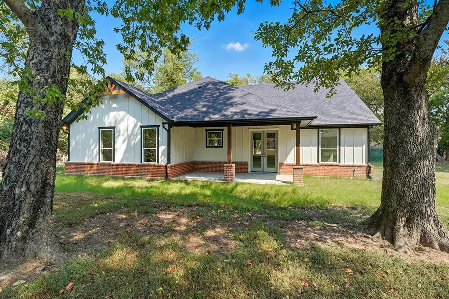 View of front of property with roof with shingles, a patio area, a front yard, and board and batten siding View of front of property with roof with shingles, a patio area, a front yard, and board and batten siding