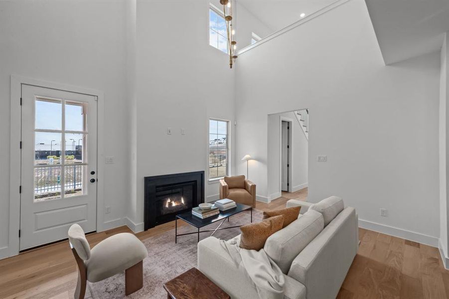 Living room featuring a towering ceiling and light hardwood / wood-style flooring