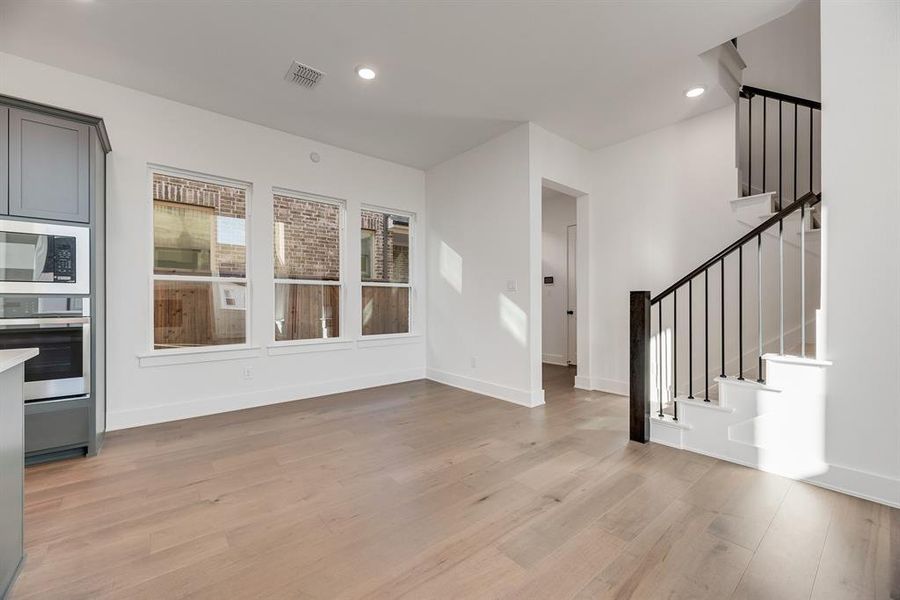 Unfurnished living room with recessed lighting, stairs, and light wood-type flooring
