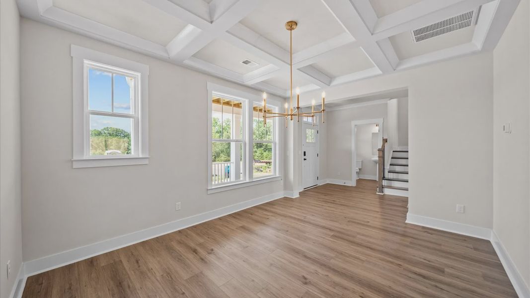Modern dining room with classic touches like a coffered ceiling in this select Benjamin's Grove home