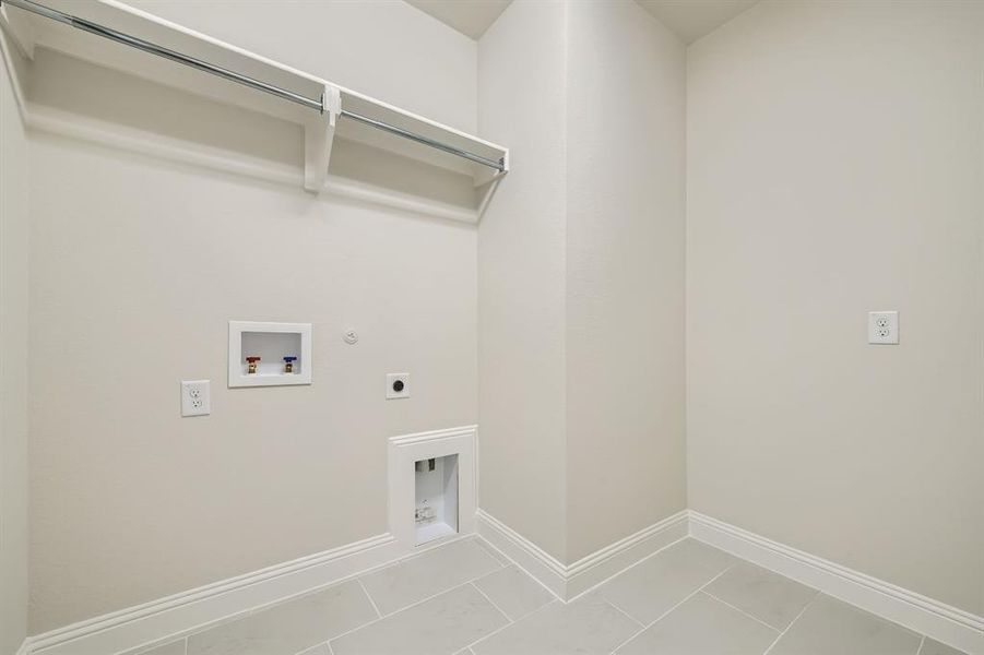 Laundry area featuring hookup for a washing machine, hookup for a gas dryer, light tile patterned floors, and electric dryer hookup