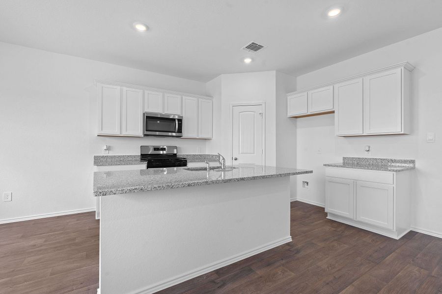 Kitchen with white cabinets, light stone countertops, stainless steel appliances, and recessed lighting Kitchen with white cabinets, light stone countertops, stainless steel appliances, and recessed lighting