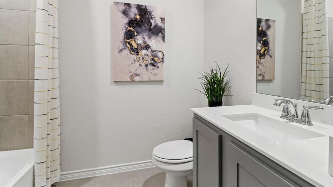 Bathroom with vanity, light tile patterned flooring, shower / bathtub combination with curtain, and a textured wall