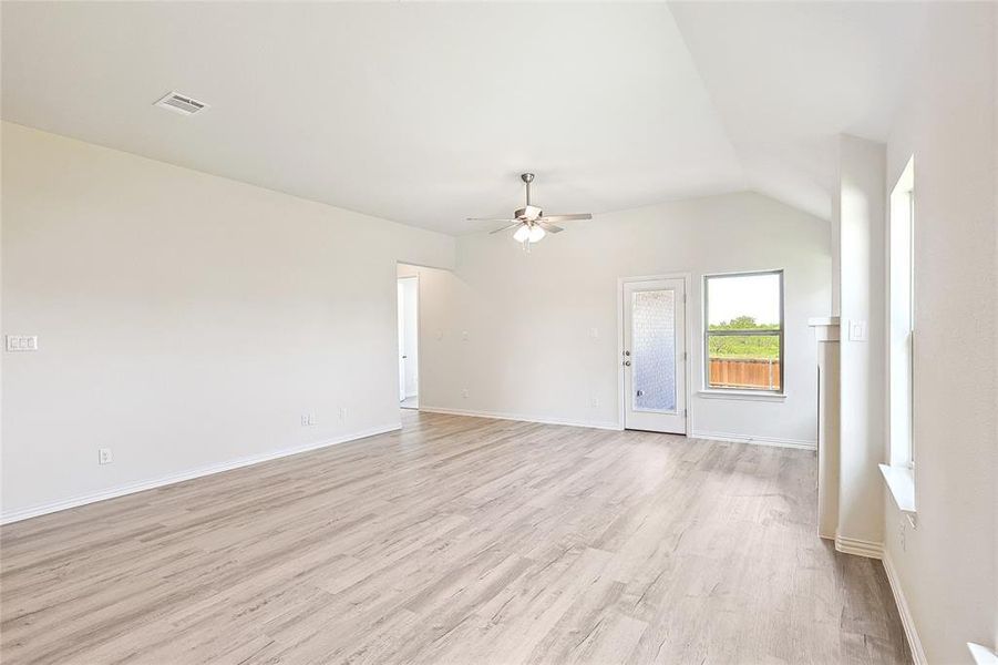 Spare room featuring vaulted ceiling, ceiling fan, and light hardwood / wood-style flooring