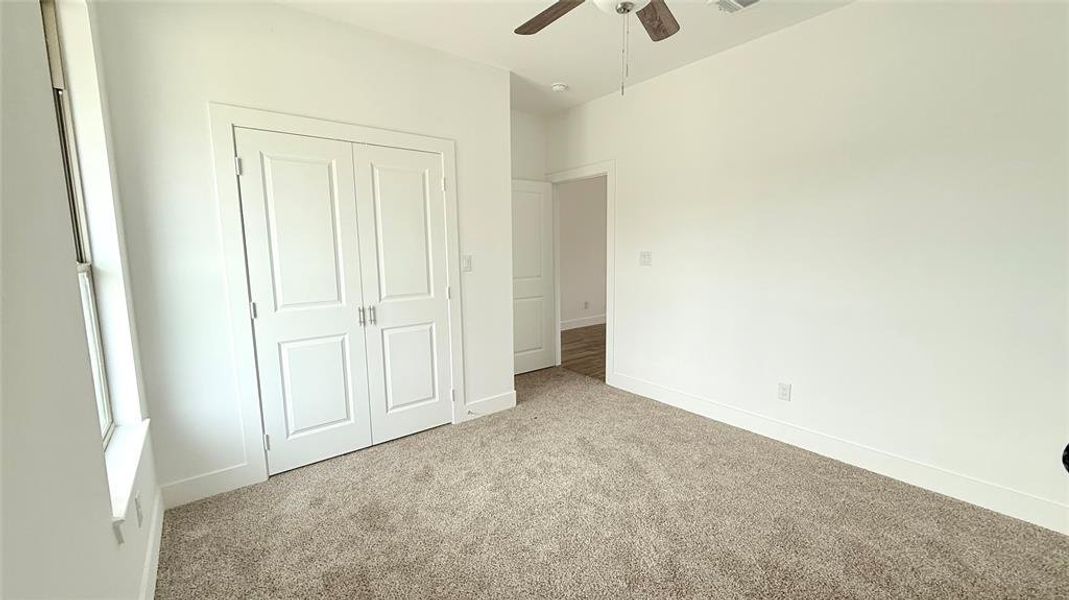 Bedroom featuring a closet, a ceiling fan, baseboards, and carpet floors