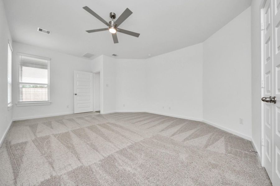 Come and unwind after a long day in this magnificent primary suite! This spacious room features plush carpet, warm paint, high ceilings and large windows with privacy blinds. Sample photo of completed home with similar floor plan. Actual colors and selections may vary.