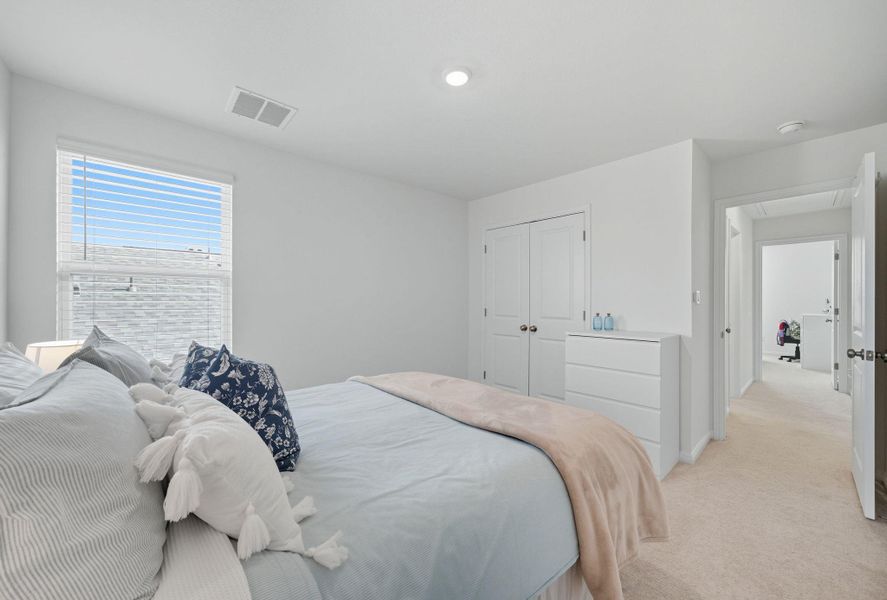 Carpeted bedroom with a closet and baseboards Carpeted bedroom with a closet and baseboards