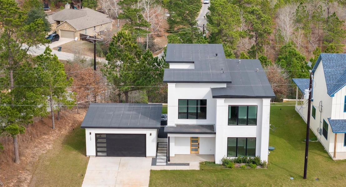 View of front of home featuring stucco siding, a front yard, and driveway