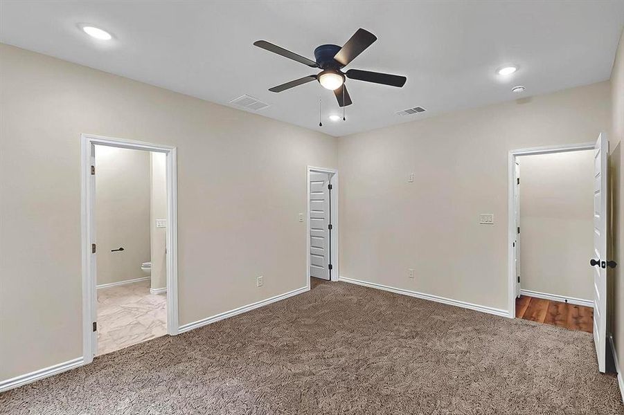 Unfurnished bedroom featuring visible vents, baseboards, carpet floors, and ensuite bath Unfurnished bedroom featuring visible vents, baseboards, carpet floors, and ensuite bath