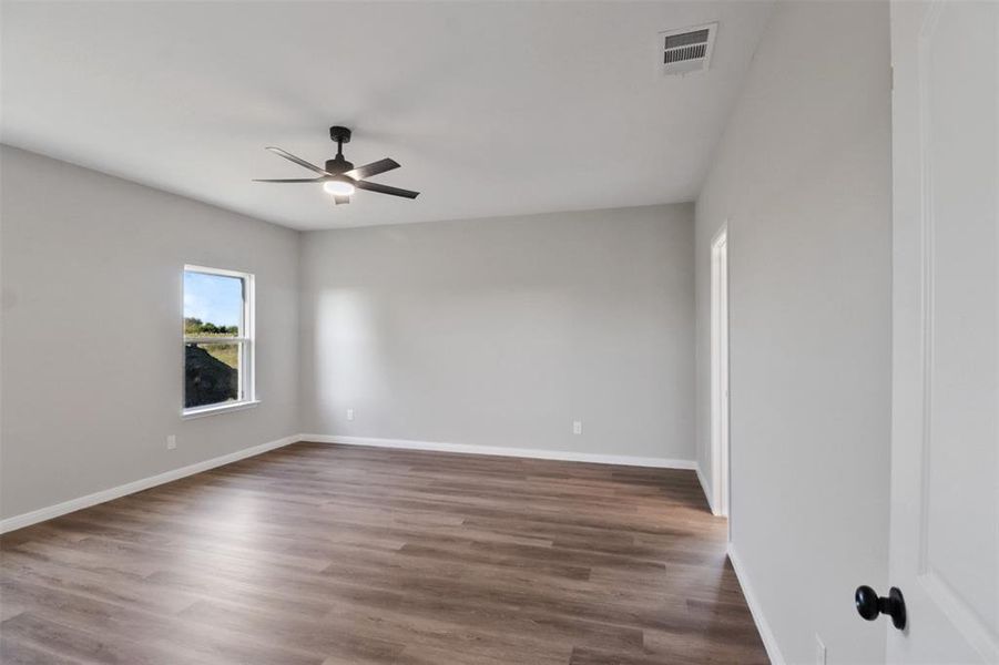 Unfurnished room with ceiling fan and dark wood-type flooring