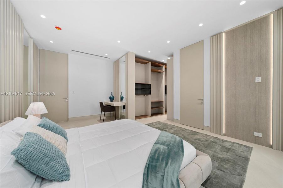 Recessed ceiling lighting, built-in open shelving, integrated wall lighting, light-toned wood-finish flooring, and a built-in desk area