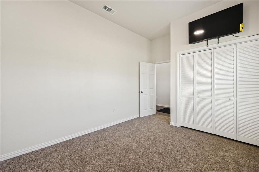 Unfurnished bedroom featuring carpet flooring and a closet