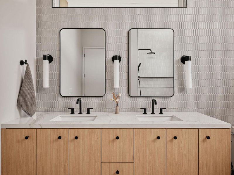 Dual vanity with wood-finish cabinetry, white countertop, and integrated sinks