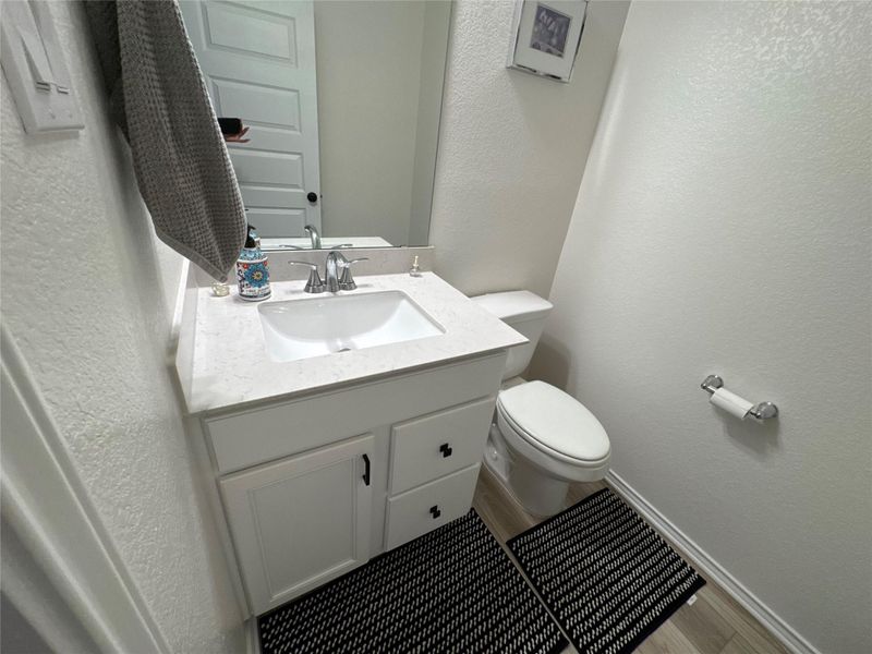 A compact and functional powder room with a sleek vanity and modern fixtures.