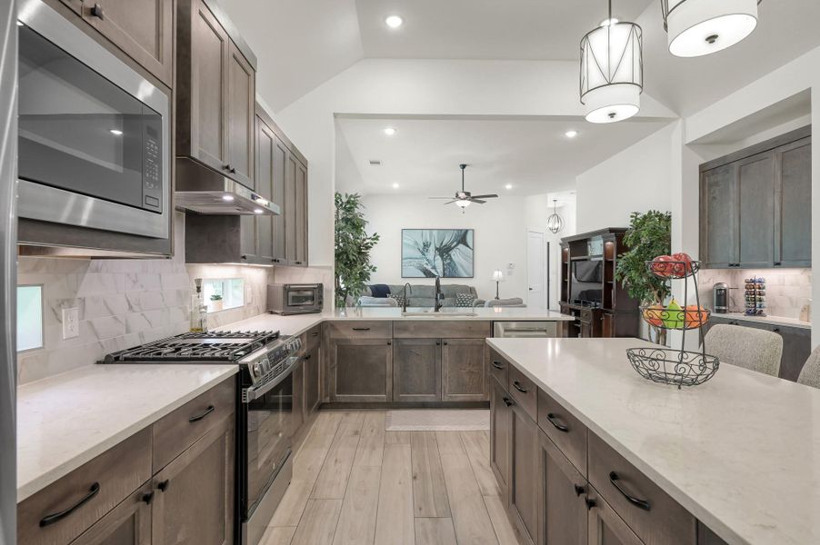 Modern kitchen complete with a premium farmhouse sink, Bosch 800-series dishwasher, upgraded vent hood, and sleek contemporary finishes throughout.