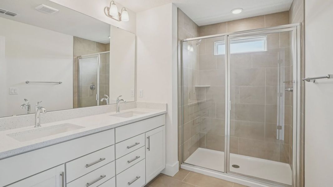 Plumeria Floor Plan primary suite bathroom with dual sinks by DRB Homes in Trailside located in Mount Dora, FL Plumeria Floor Plan primary suite bathroom with dual sinks by DRB Homes in Trailside located in Mount Dora, FL