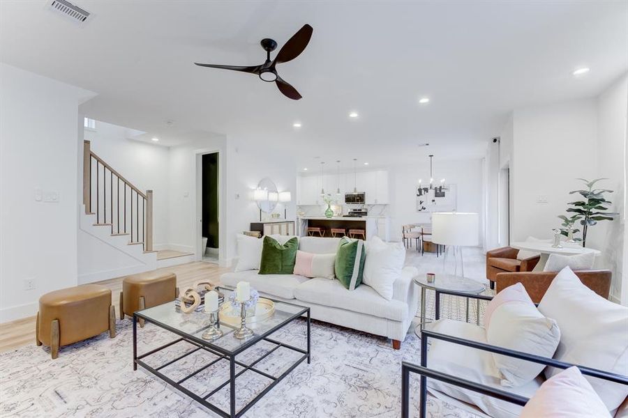 The spacious living room is open to the kitchen and has plenty of natural lighting from the windows. There is also recessed lighting.